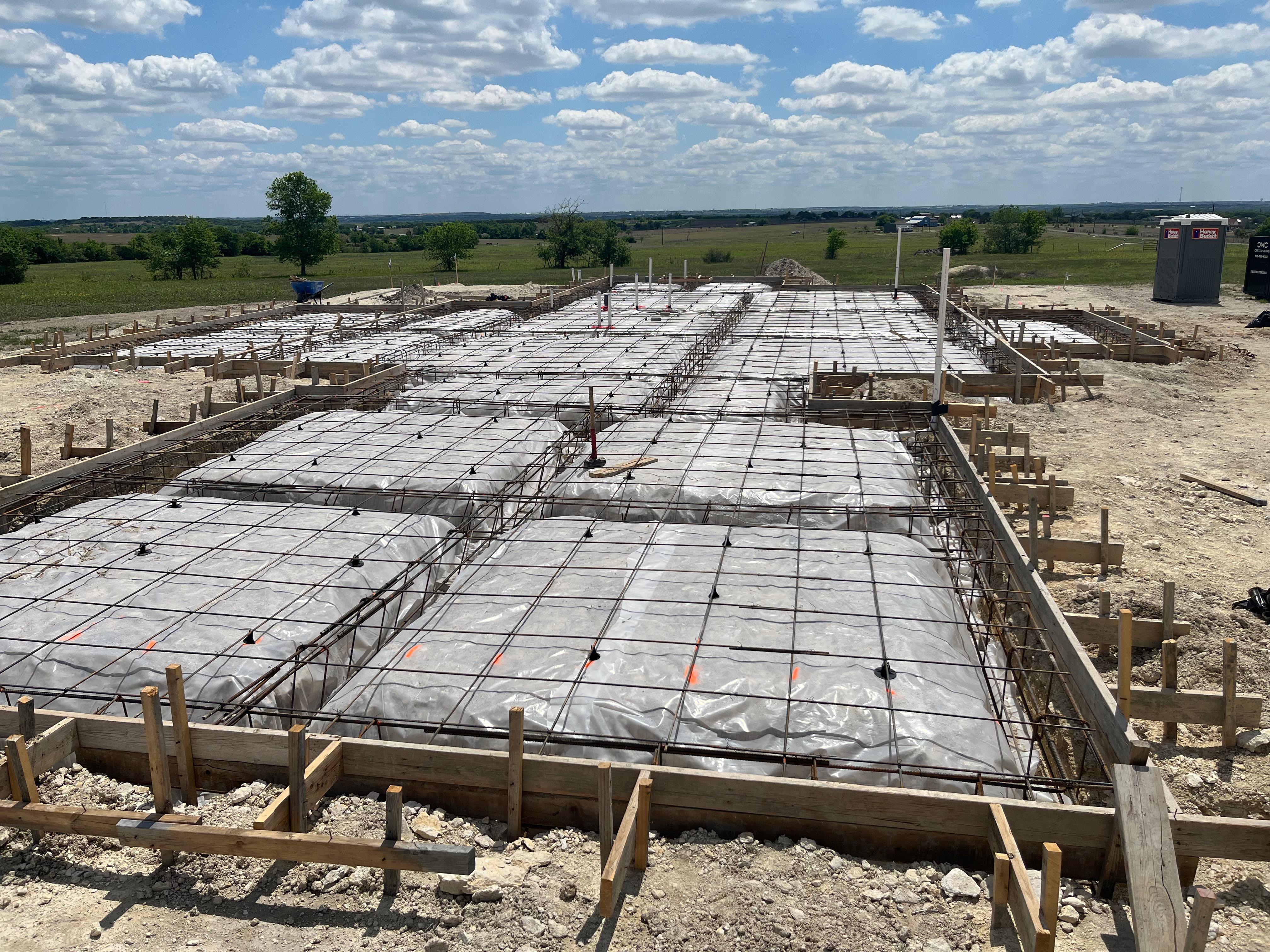 Large commercial foundation with rebar grid and vapor barrier ready for pour — APC